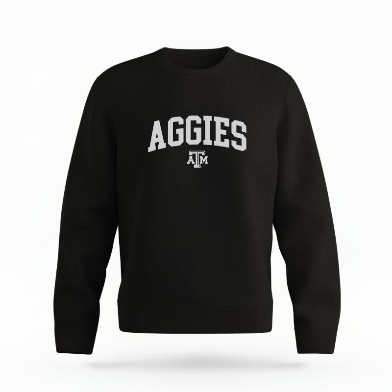 The Black Unisex Aggies Varsity Organic Cotton Crewneck is set against a Ghost - White Studio background. The Aggies Varsity graphic is in a Sports Graphics style.