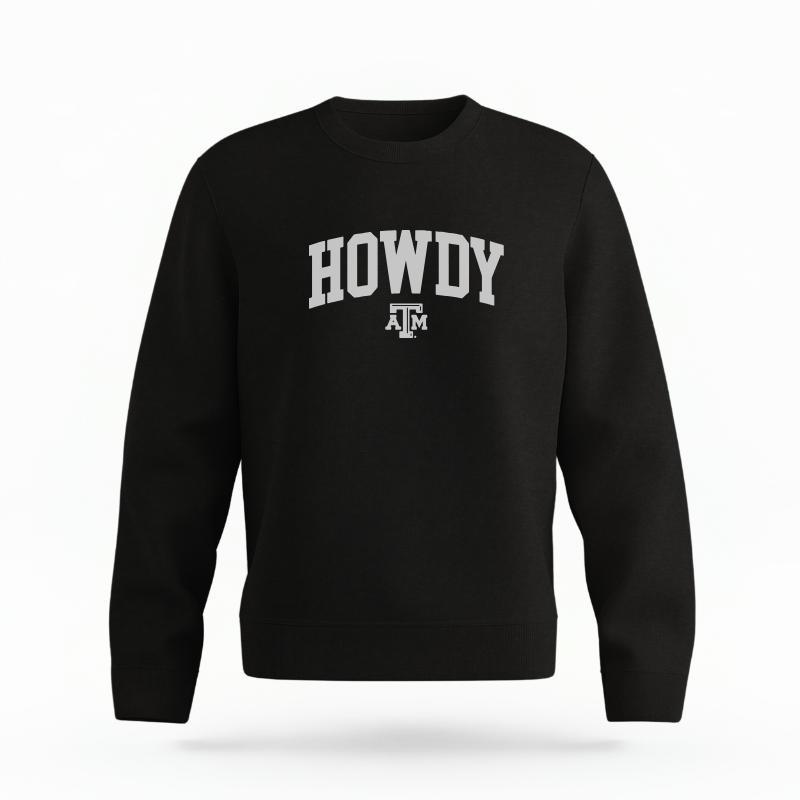 The Black Unisex Howdy Varsity Organic Cotton Crewneck is set against a Ghost - White Studio background. The Howdy Varsity graphic is in a Sports Graphics style.
