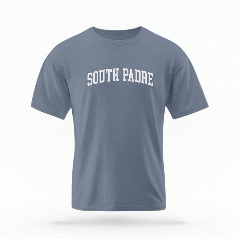 The Blue Jean Unisex South Padre Varsity T-shirt is set against a Ghost - White Studio background. The South Padre Varsity graphic is in a Varsity style.