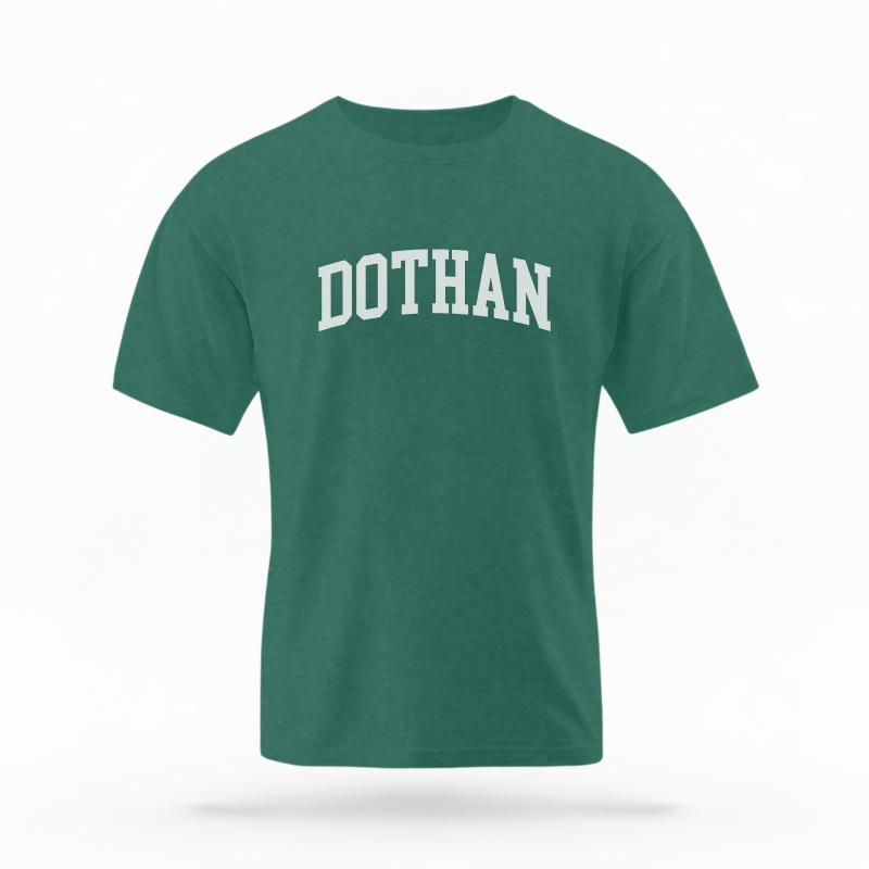 The Blue Spruce Unisex Dothan, AL Varsity T-shirt is set against a Ghost - White Studio background. The Dothan, AL Varsity graphic is in a Varsity style.