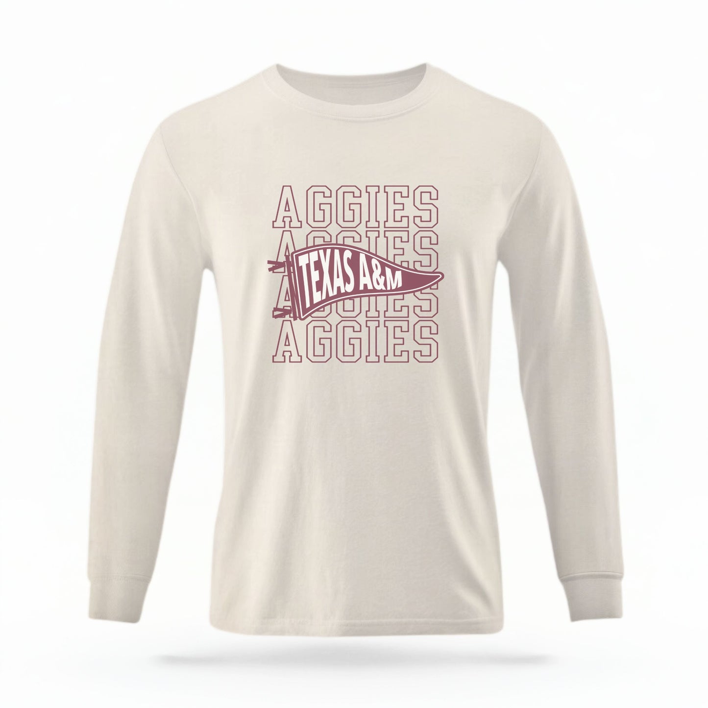 The Ivory Unisex Aggies Pennant Long Sleeve T-shirt is set against a Ghost - White Studio background. The Aggies Pennant graphic is in a Sports Graphics style.