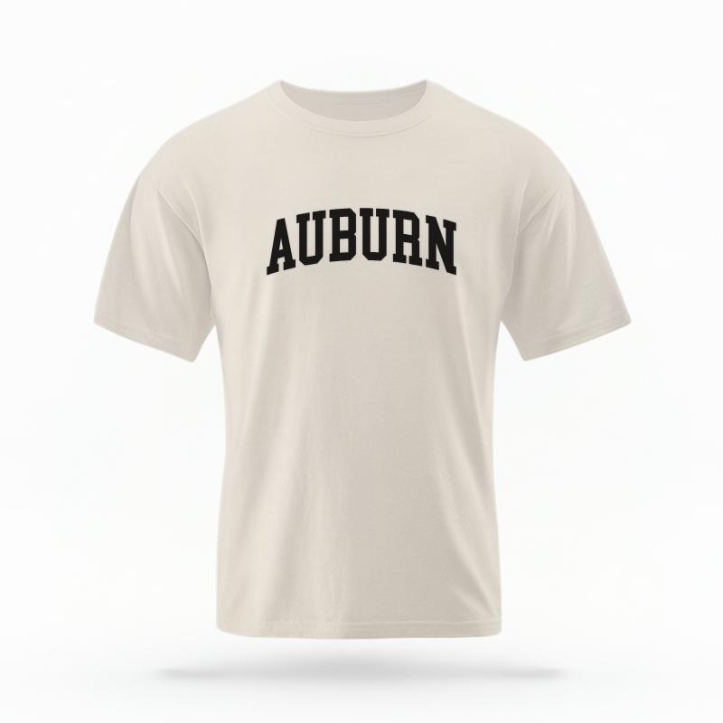 The Ivory Unisex Auburn Varsity T-shirt is set against a Ghost - White Studio background. The Auburn Varsity graphic is in a Varsity style.