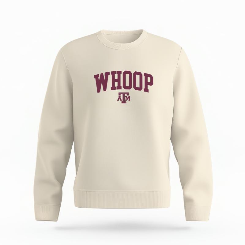 The Ivory Unisex Whoop Varsity Organic Cotton Crewneck is set against a Ghost - White Studio background. The Whoop Varsity graphic is in a Sports Graphics style.