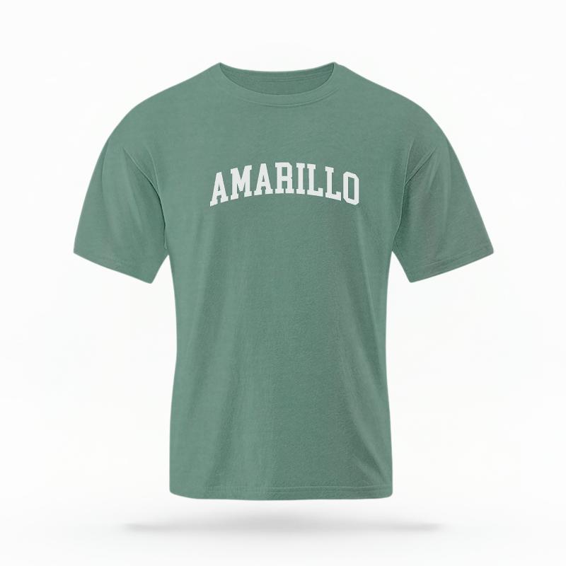The Light Green Unisex Amarillo Varsity T-shirt is set against a Ghost - White Studio background. The Amarillo Varsity graphic is in a Varsity style.