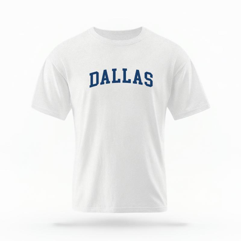 The White Unisex Dallas Varsity T-shirt is set against a Ghost - White Studio background. The Dallas Varsity graphic is in a Varsity style.
