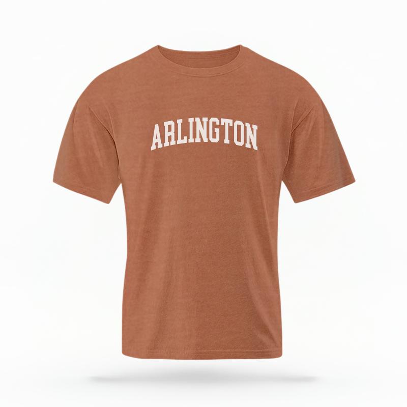 The Yam Unisex Arlington Varsity T-shirt is set against a Ghost - White Studio background. The Arlington Varsity graphic is in a Varsity style.