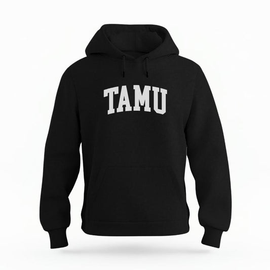 The Black Unisex TAMU Varsity Organic Cotton Hoodie is set against a Ghost - White Studio background.  The TAMU Varsity graphic is in a Sports Graphics style. 