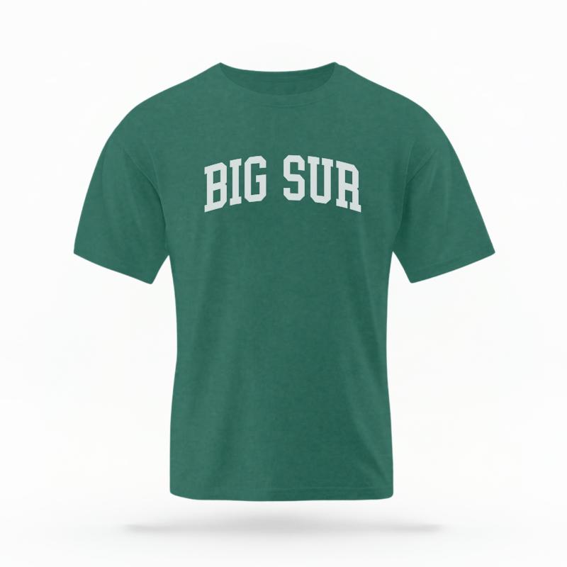 The Blue Spruce Unisex Big Sur CA Varsity T-shirt is set against a Ghost - White Studio background.  The Big Sur CA Varsity graphic is in a Varsity style. 