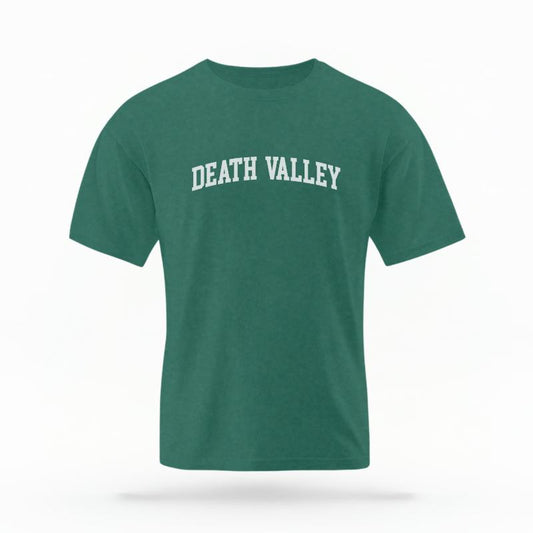 The Blue Spruce Unisex Death Valley CA Varsity T-shirt is set against a Ghost - White Studio background.  The Death Valley CA Varsity graphic is in a Varsity style. 