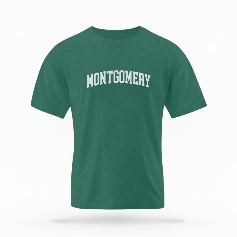 The Blue Spruce Unisex Montgomery, AL Varsity T-shirt is set against a Ghost - White Studio background.  The Montgomery, AL Varsity graphic is in a Varsity style. 