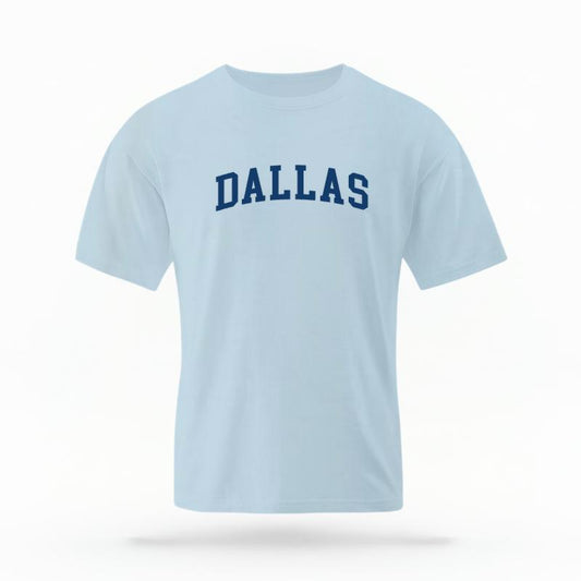 The Chambray Unisex Dallas Varsity T-shirt is set against a Ghost - White Studio background.  The Dallas Varsity graphic is in a Varsity style. 