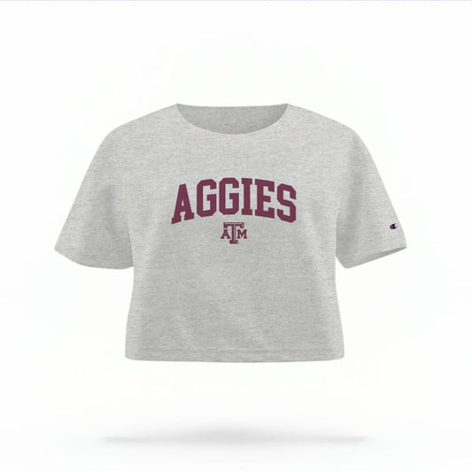 The Heather Grey Female Aggies Varsity Women's Boxy Crop Top is set against a Ghost - White Studio background.  The Aggies Varsity graphic is in a Sports Graphics style. 