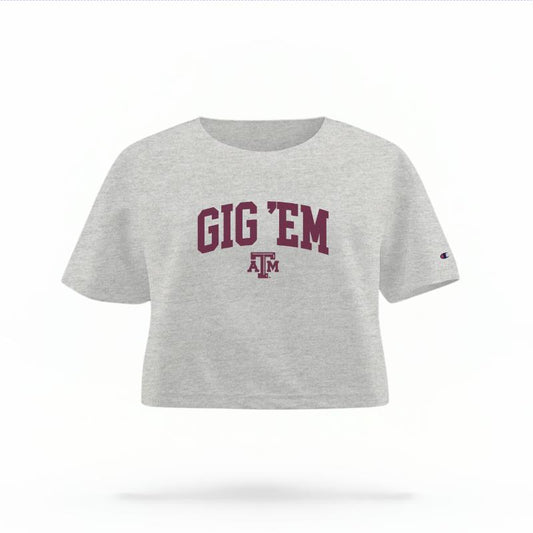 The Heather Grey Female Gig 'Em Varsity Women's Boxy Crop Top is set against a Ghost - White Studio background.  The Gig 'Em Varsity graphic is in a Sports Graphics style. 