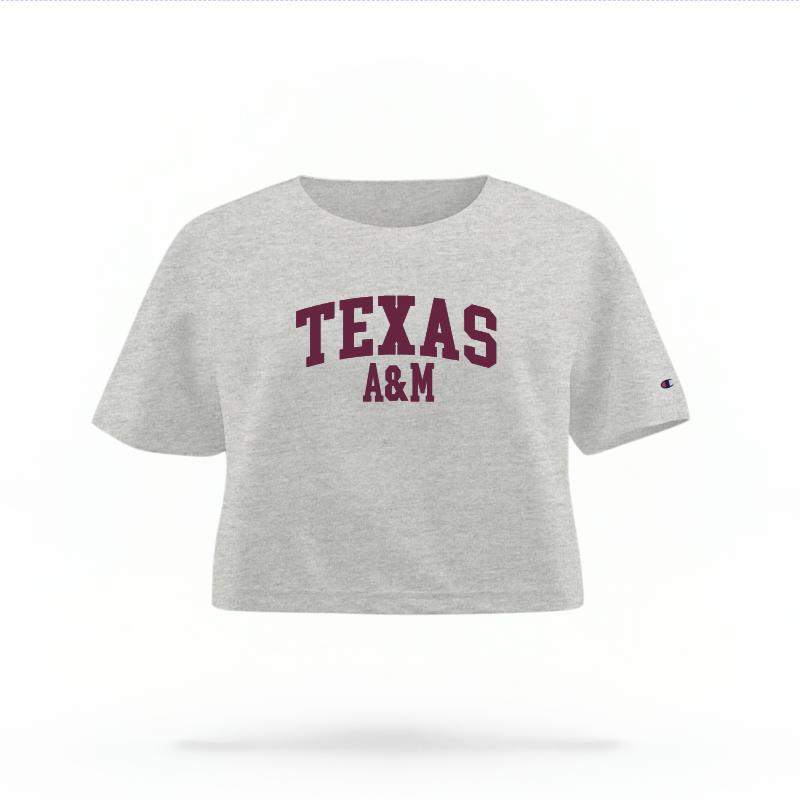 The Heather Grey Female Texas A&M Varsity Women's Boxy Crop Top is set against a Ghost - White Studio background.  The Texas A&M Varsity graphic is in a Sports Graphics style. 