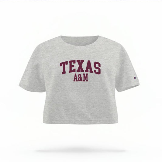 The Heather Grey Female Texas A&M Varsity Women's Boxy Crop Top is set against a Ghost - White Studio background.  The Texas A&M Varsity graphic is in a Sports Graphics style. 