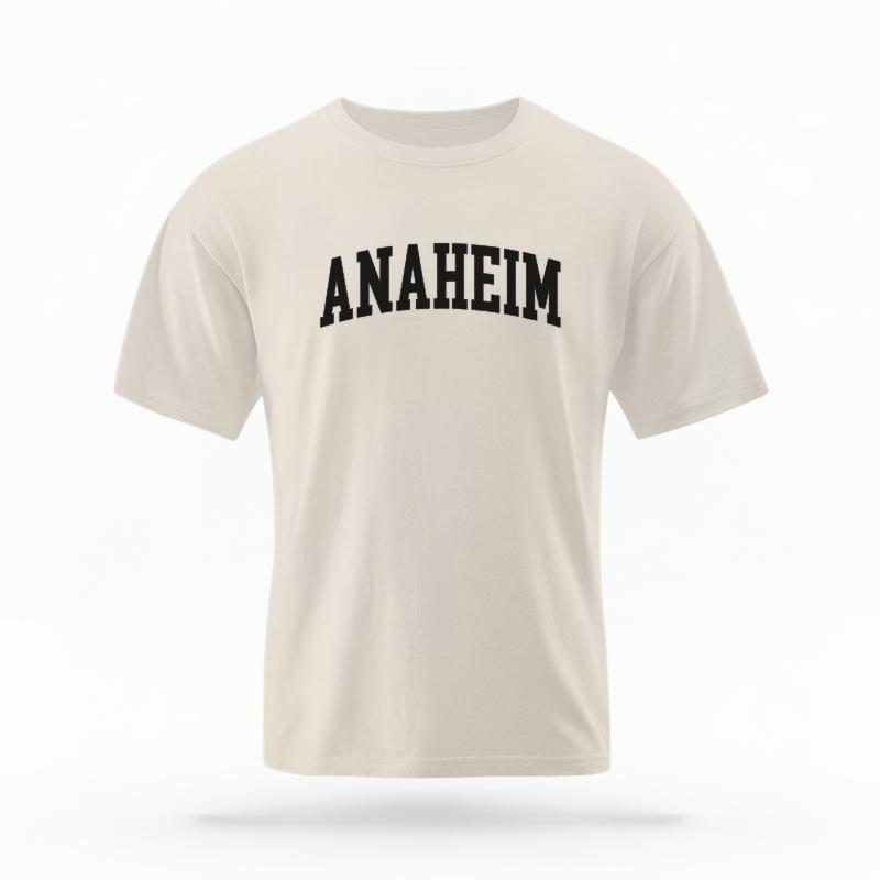 The Ivory Unisex Anaheim CA Varsity T-shirt is set against a Ghost - White Studio background.  The Anaheim CA Varsity graphic is in a Varsity style. 
