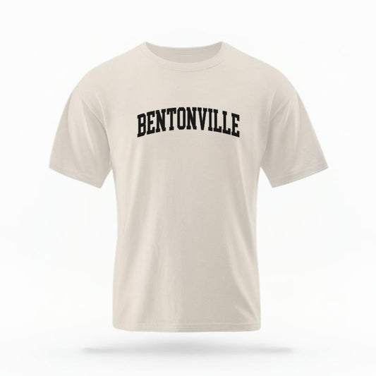 The Ivory Unisex Bentonville AR Varsity T-shirt is set against a Ghost - White Studio background.  The Bentonville AR Varsity graphic is in a Varsity style. 