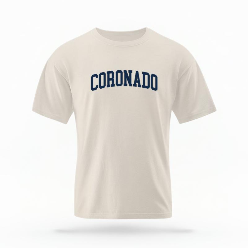 The Ivory Unisex Coronado CA Varsity T-shirt is set against a Ghost - White Studio background.  The Coronado CA Varsity graphic is in a Varsity style. 