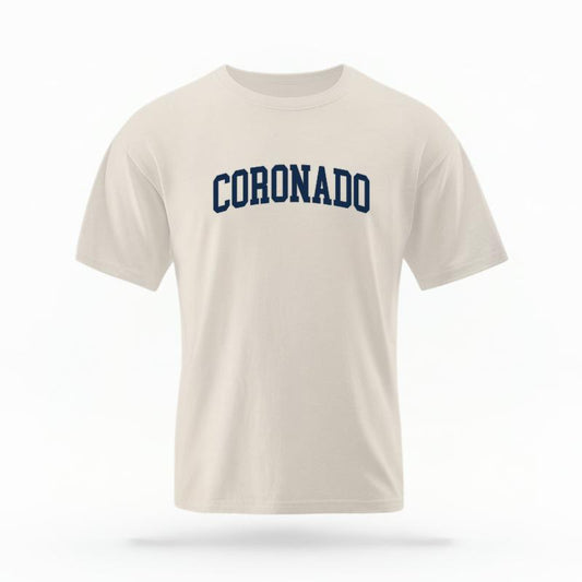 The Ivory Unisex Coronado CA Varsity T-shirt is set against a Ghost - White Studio background.  The Coronado CA Varsity graphic is in a Varsity style. 