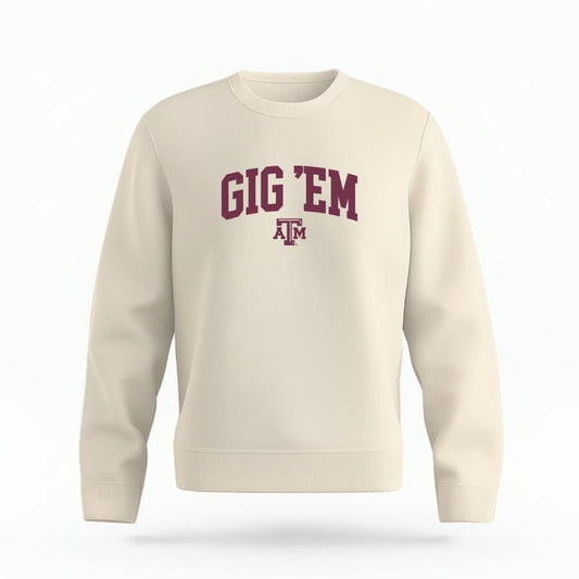 The Ivory Unisex Gig 'Em Varsity Organic Cotton Crewneck is set against a Ghost - White Studio background.  The Gig 'Em Varsity graphic is in a Sports Graphics style. 