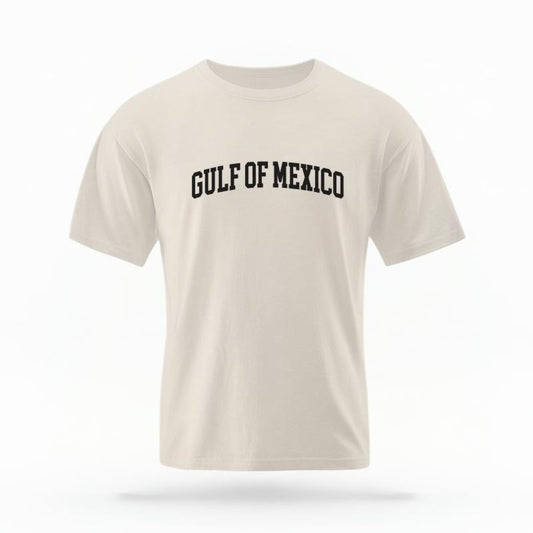 The Ivory Unisex Gulf of Mexico Varsity T-shirt is set against a Ghost - White Studio background.  The Gulf of Mexico Varsity graphic is in a Varsity style. 