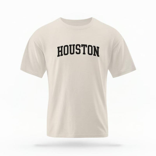 The Ivory Unisex Houston Varsity T-shirt is set against a Ghost - White Studio background.  The Houston Varsity graphic is in a Varsity style. 