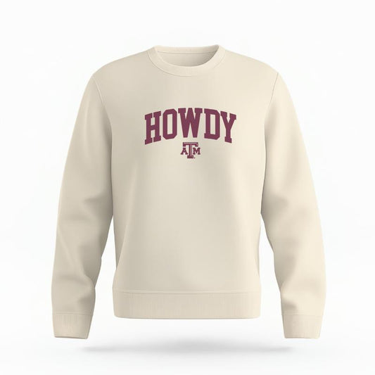 The Ivory Unisex Howdy Varsity Organic Cotton Crewneck is set against a Ghost - White Studio background.  The Howdy Varsity graphic is in a Sports Graphics style. 