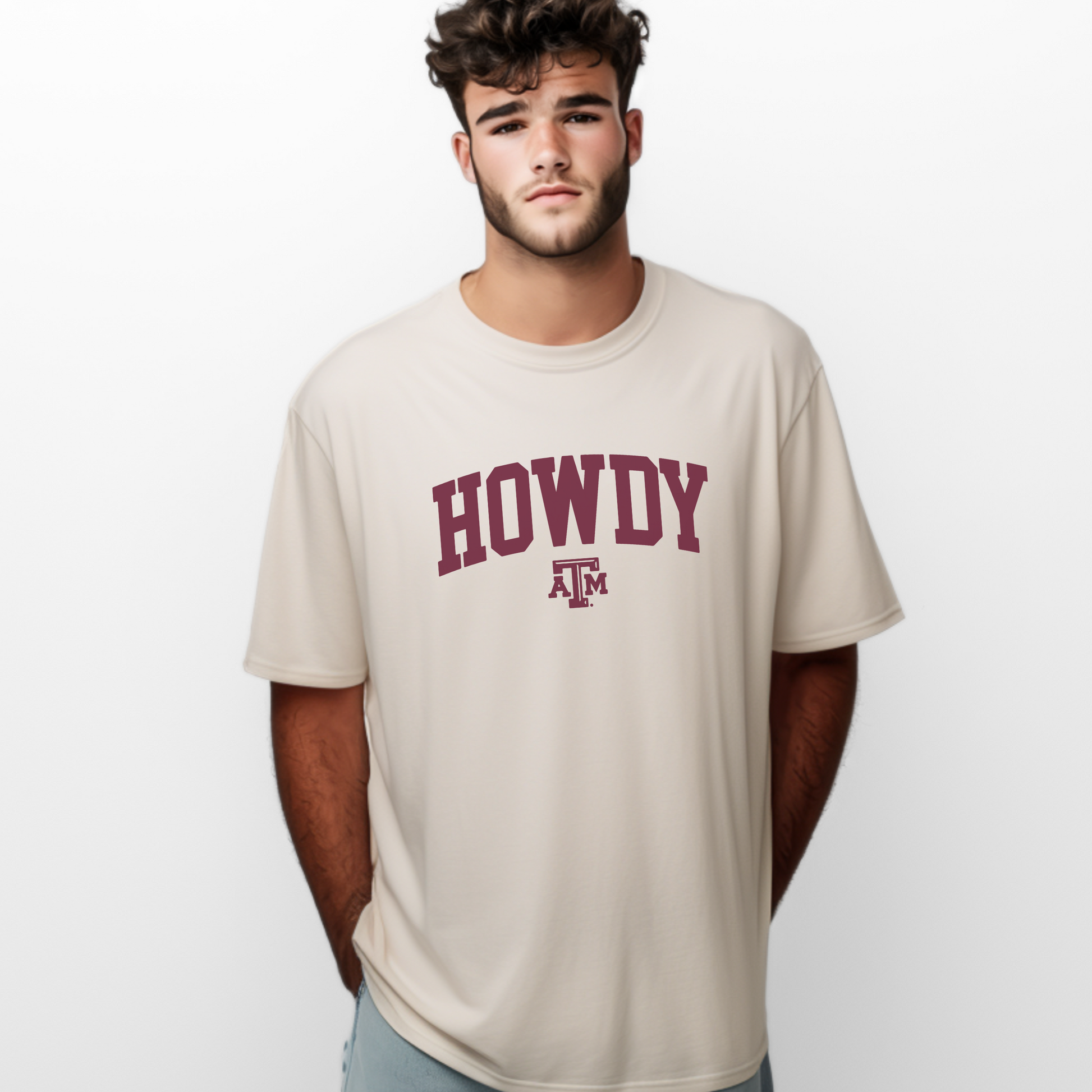 The Ivory Unisex Howdy Varsity T-shirt is worn by a model.  The Howdy Varsity graphic is in a Varsity style. 