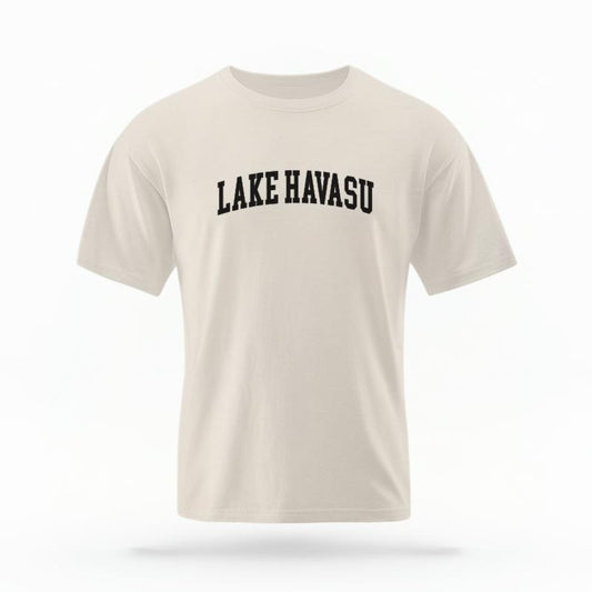 The Ivory Unisex Lake Havasu AZ Varsity T-shirt is set against a Ghost - White Studio background.  The Lake Havasu AZ Varsity graphic is in a Varsity style. 