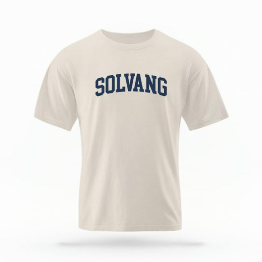 The Ivory Unisex Solvang CA Varsity T-shirt is set against a Ghost - White Studio background.  The Solvang CA Varsity graphic is in a Varsity style. 