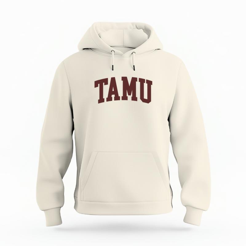 The Ivory Unisex TAMU Varsity Organic Cotton Hoodie is set against a Ghost - White Studio background.  The TAMU Varsity graphic is in a Sports Graphics style. 