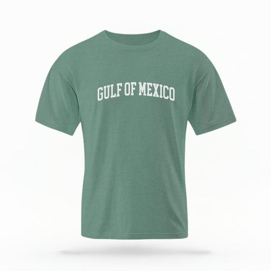The Light Green Unisex Gulf of Mexico Varsity T-shirt is set against a Ghost - White Studio background.  The Gulf of Mexico Varsity graphic is in a Varsity style. 