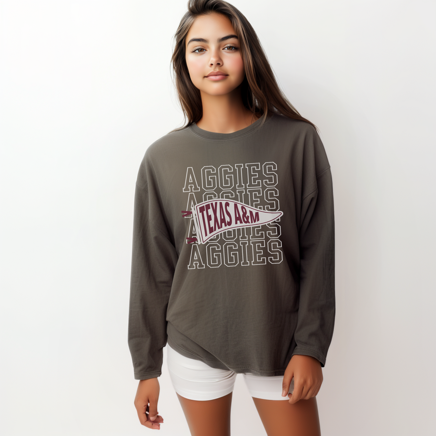 The Pepper Unisex Aggies Pennant Long Sleeve T-shirt is worn by a woman.  The Aggies Pennant graphic is in a Sports Graphics style. 