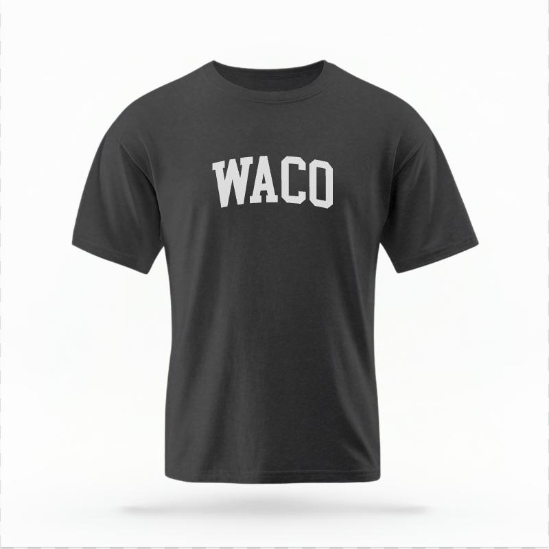 The Pepper Unisex Waco Varsity T-shirt is set against a Ghost - White Studio background.  The Waco Varsity graphic is in a Varsity style. 