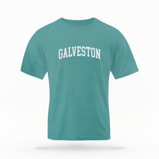 The Seafoam Unisex Galveston Varsity T-shirt is set against a Ghost - White Studio background.  The Galveston Varsity graphic is in a Varsity style. 