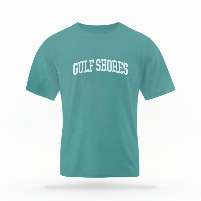The Seafoam Unisex Gulf Shores, AL Varsity T-shirt is set against a Ghost - White Studio background.  The Gulf Shores, AL Varsity graphic is in a Varsity style. 