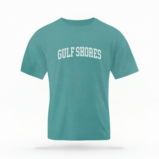The Seafoam Unisex Gulf Shores, AL Varsity T-shirt is set against a Ghost - White Studio background.  The Gulf Shores, AL Varsity graphic is in a Varsity style. 