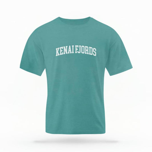 The Seafoam Unisex Kenai Fjords Alaska Varsity T-shirt is set against a Ghost - White Studio background.  The Kenai Fjords Alaska Varsity graphic is in a Varsity style. 