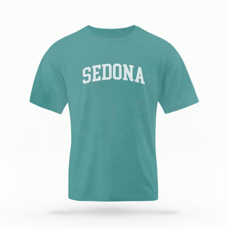 The Seafoam Unisex Sedona AZ Varsity T-shirt is set against a Ghost - White Studio background.  The Sedona AZ Varsity graphic is in a Varsity style. 