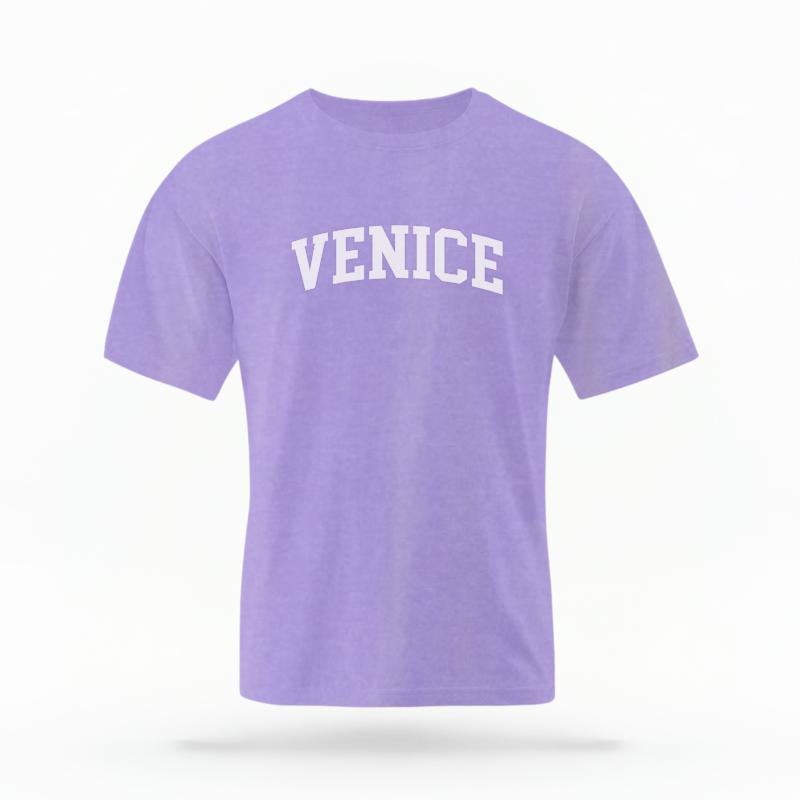 The Violet Unisex Venice CA Varsity T-shirt is set against a Ghost - White Studio background.  The Venice CA Varsity graphic is in a Varsity style. 