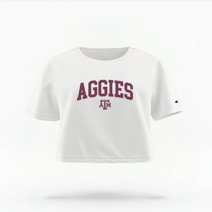 The White Female Aggies Varsity Women's Boxy Crop Top is set against a Ghost - White Studio background.  The Aggies Varsity graphic is in a Sports Graphics style. 