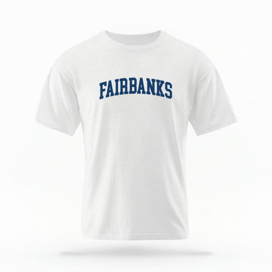 The White Unisex Fairbanks Alaska Varsity T-shirt is set against a Ghost - White Studio background.  The Fairbanks Alaska Varsity graphic is in a Varsity style. 