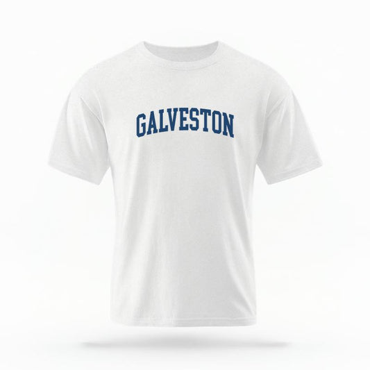 The White Unisex Galveston Varsity T-shirt is set against a Ghost - White Studio background.  The Galveston Varsity graphic is in a Varsity style. 