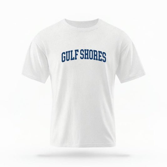 The White Unisex Gulf Shores, AL Varsity T-shirt is set against a Ghost - White Studio background.  The Gulf Shores, AL Varsity graphic is in a Varsity style. 
