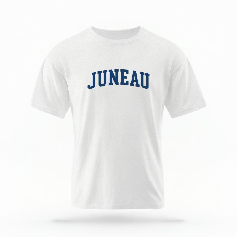 The White Unisex Juneau Alaska Varsity T-shirt is set against a Ghost - White Studio background.  The Juneau Alaska Varsity graphic is in a Varsity style. 