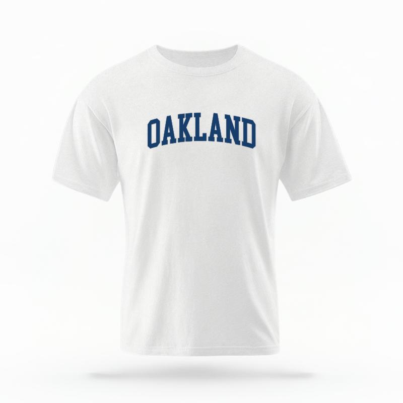 The White Unisex Oakland CA Varsity T-shirt is set against a Ghost - White Studio background.  The Oakland CA Varsity graphic is in a Varsity style. 