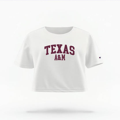 The White Female Texas A&M Varsity Women's Boxy Crop Top is set against a Ghost - White Studio background.  The Texas A&M Varsity graphic is in a Sports Graphics style. 